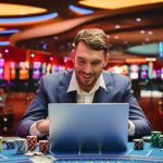 man on a laptop with a casino background